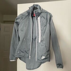 Nike Women's Tech Aeroshield Moto Cape jacket,grey unique drop-tail hem design.